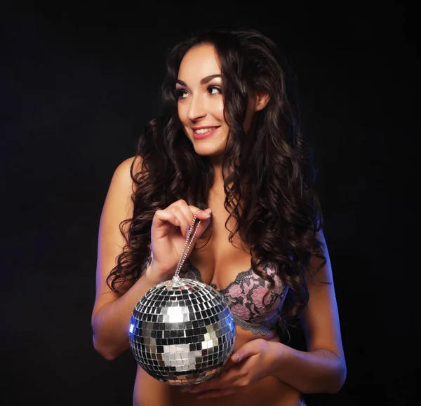 Jovem morena vestindo lingerie com bola de discoteca, posando em estúdio — Fotografia de Stock