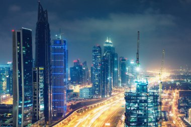 Gece Dubai şehir merkezinde. Otoyollar ve gökdelenler üzerinde manzara hava görünümü.