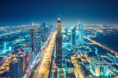 Gece Dubai şehir merkezinde. Otoyollar ve gökdelenler üzerinde manzara hava görünümü.