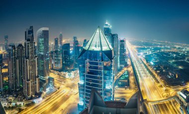 Gece Dubai şehir merkezinde. Otoyollar ve gökdelenler üzerinde manzara hava görünümü.