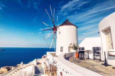 Oia köyünde eski değirmen, Yunanistan Santorini adasında, dramatik gökyüzü ile güneşli bir günde. Doğal seyahat arka plan.