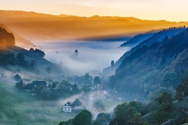 Doğal dağ manzarası. Almanya'da pitoresk bir köy, Kara Orman, sis kaplı görünümü. Renkli seyahat arka plan.