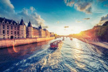 Paris, Fransa'da Seine Nehri üzerinde Conciergerie ve Pont Neuf ile dramatik gün batımı. Renkli seyahat arka planı. Romantik şehir manzarası.