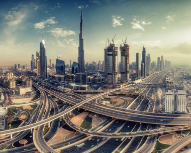 Dubai, Bae' de gündüz büyük otoyol kavşağı ve gökdelenler üzerinde havadan görünüm. Manzaralı şehir manzarası. Tonda seyahat ve mimari arka plan.