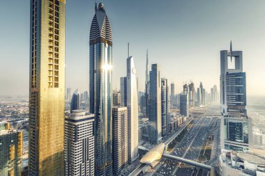 Gökdelenler ve gün batımında büyük bir modern şehrin karayolları. Dubai şehir merkezinde havadan görünüm, Birleşik Arap Emirlikleri.