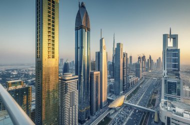 Gökdelenler ve gün batımında büyük bir modern şehrin karayolları. Dubai şehir merkezinde havadan görünüm, Birleşik Arap Emirlikleri.