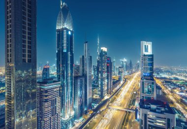 Dubai, Bae şehir merkezinde gökdelenler ve otoyollar. Büyük modern bir şehrin gece silueti.