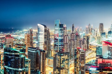Büyük ve modern bir şehrin renkli gece silueti. Dubai, Birleşik Arap Emirlikleri. Otoyollarda ve gökdelenlerde havadan görünüm.