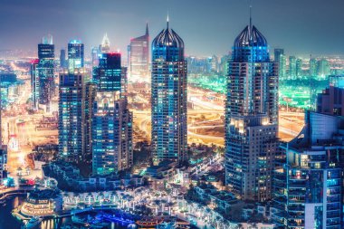 Büyük modern şehrin doğal gece silueti. Dubai Marina, Bae gökdelenler ve karayolları üzerinde havadan görünümü. Çok renkli seyahat arka planı.