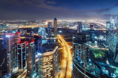 Büyük fütüristik bir şehrin doğal gece silueti. Downtown Dubai, Birleşik Arap Emirlikleri. Otoyollarda ve gökdelenlerde havadan görünüm.