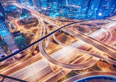 Dubai, Bae, gece trafik ile büyük karayolu kavşak havadan görünümü. Manzaralı şehir manzarası. Renkli ulaşım, iletişim ve sürüş arka plan.