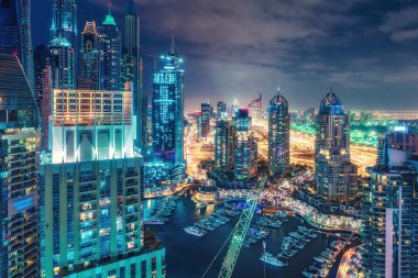 Büyük modern şehrin doğal gece silueti. Dubai Marina, Bae gökdelenler ve karayolları üzerinde havadan görünümü. Çok renkli seyahat arka planı.