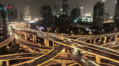 Şangay, Çin'de otoyol kavşağı, geceleri. Hızlı hareket eden arabalar ile büyük ışıklı kavşak Manzara havadan görünümü. 4k Zaman atlamalı.