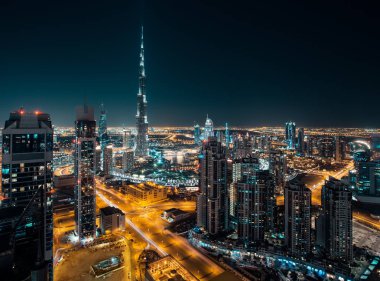 Işıklı gökdelenler ile gece Dubai'nin modern mimarisinin fantastik çatı görünümü. 