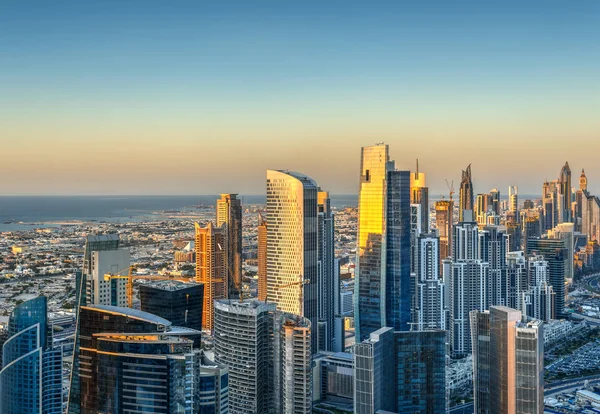 Altın gün batımında güzel modern şehir architecure. Dubai'nin iş bölümü kulelerinin görünümü.