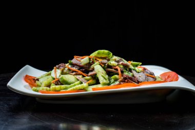 Çin mutfağı, siyah zemin üzerine beyaz tabak içinde salatalık ve domates ile sığır eti haşlama