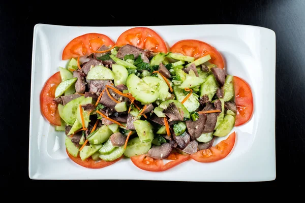 Çin mutfağı, siyah zemin üzerine beyaz tabak içinde salatalık ve domates ile sığır eti haşlama