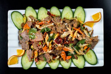 Çin mutfağı, siyah zemin üzerine beyaz tabak içinde salatalık ve domates ile sığır eti haşlama