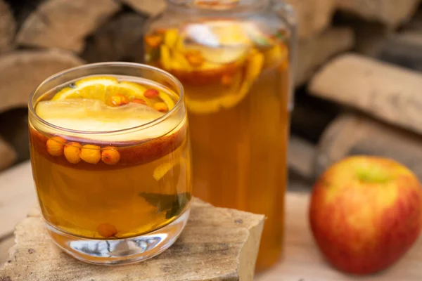 hot autumn drink cider from apples with lemon, cinnamon, sea buckthorn and anise stars