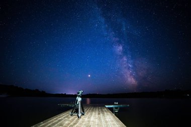 Gece Samanyolu ile ahşap iskele kamera bir tripod üzerinde