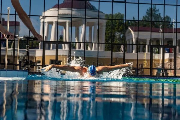 Man swims using breaststroke technique . pool turquoise water