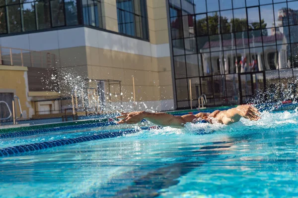 L'homme nage en utilisant la technique du brasse. piscine eau turquoise — Photo