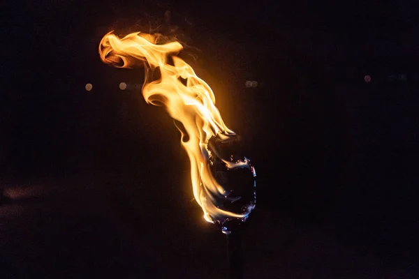 Горящий факел ночью на черном фоне — стоковое фото