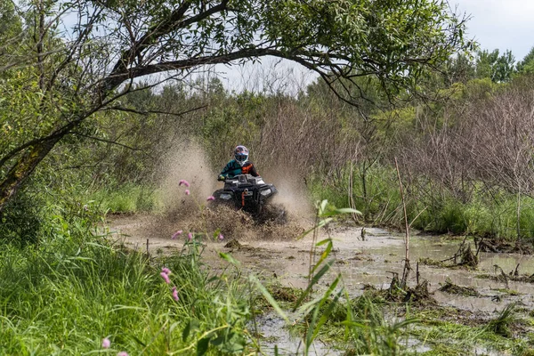 ATV Quad jezdí rychle na velké nečistoty a dělá postříkání špinavé vody — Stock fotografie