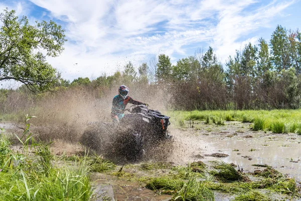 ATV-Quad fährt schnell über großen Schmutz und macht Spritzer Schmutzwasser — Stockfoto