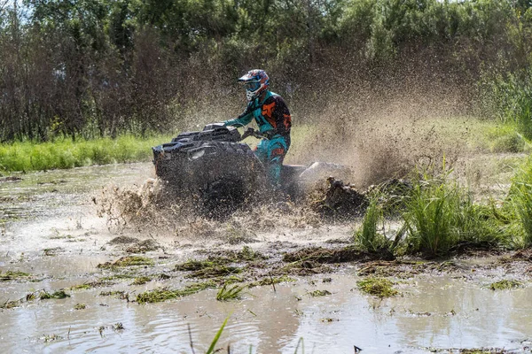 ATV-Quad fährt schnell über großen Schmutz und macht Spritzer Schmutzwasser — Stockfoto