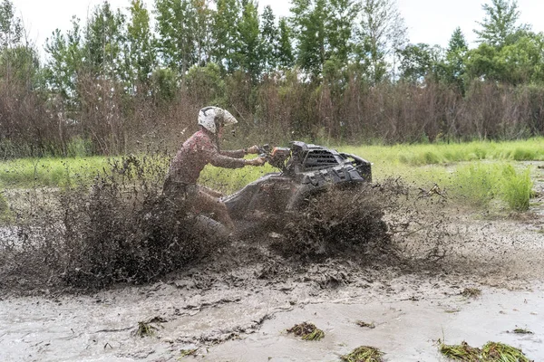 ATV Quad monta rápido en la tierra grande y hace salpicaduras de agua sucia —  Fotos de Stock