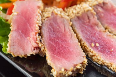 Natürmort otlar ve susam koyu gri yüzeyi ile kabuklu kavrulmuş orkinos biftek kadar kapatın