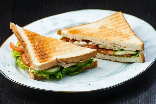 Sandwich con jamón, queso, tomates, lechuga y pan tostado. Vista superior aislada sobre fondo oscuro — Foto de Stock