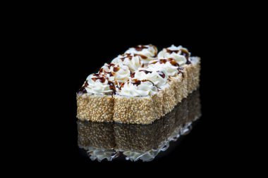 Suşi somon, ton balığı, salatalık ve yeşil soğan ile siyah arka plan üzerine rulo