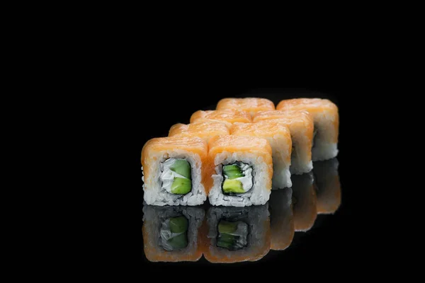 Sushi rullar med lax, tonfisk, gurka och salladslök på svart bakgrund — Stockfoto