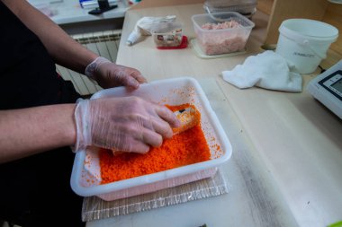 Japon suşisi yapan el yapımı bir aşçı. Japon şef işteki lezzetli suşi rulosunu yılan balığı ve avokado ile hazırlıyor. Japon yemekleri iştah açıcı..