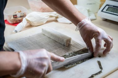 Japon suşisi yapan el yapımı bir aşçı. Japon şef işteki lezzetli suşi rulosunu yılan balığı ve avokado ile hazırlıyor. Japon yemekleri iştah açıcı..