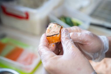 Japon suşisi yapan el yapımı bir aşçı. Japon şef işteki lezzetli suşi rulosunu yılan balığı ve avokado ile hazırlıyor. Japon yemekleri iştah açıcı..