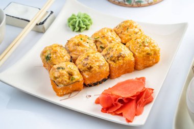 Altın kenarlıklı beyaz plaka üzerinde pişmiş rulo tarak, baharatlı sosu, krem peynir ve pirinç ile mango. Asya menü