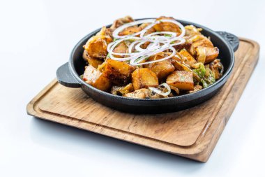 Rosemary bir ahşap masa üstü görünümde bir tavada et, brokoli ve kırmızı soğan kızarmış patatesle süslenmiş