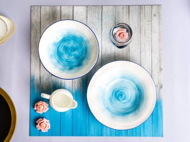 Yuvarlak, kare, oval beyaz, mavi, pembe üzerinde gri plaka, ahşap, mavi arka plan, üst görünüm