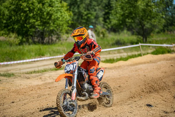 KHABAROVSK, RÚSSIA - 16 de junho de 2019: Criança piloto em motocicleta participa de motocross-country em voo, pula e decola no trampolim contra o céu. Conceito ativo extremo resto adolescente . — Fotografia de Stock