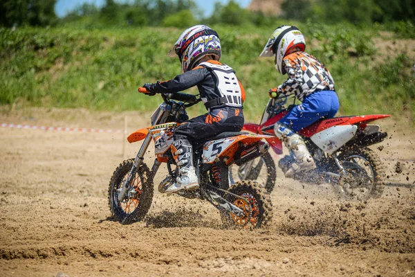 Chabaraovsk, Rusland-16 juni 2019: racer Child op de motorfiets neemt deel aan motorcross Cross-Country tijdens de vlucht, springt en neemt af op de Springplank tegen de hemel. Concept Active extreme rest tiener. — Stockfoto