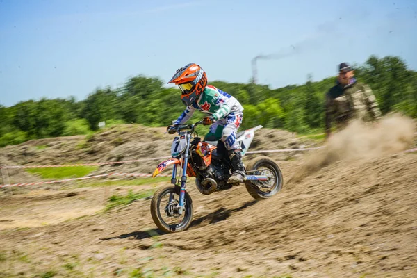 KHABAROVSK, RUSIA - 16 de junio de 2019: Niño corredor en motocicleta participa en motocross cross-country en vuelo, salta y despega en trampolín contra el cielo. Concepto activo descanso extremo adolescente . — Foto de Stock