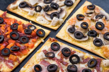 Çeşitli pizza dilimleri. Margherita, pepperoni, dört peynirli pizza. Üst te. Dokulu eski ahşap masa üzerinde pizza farklı türleri.