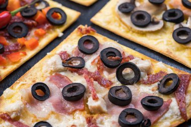 Çeşitli pizza dilimleri. Margherita, pepperoni, dört peynirli pizza. Üst te. Dokulu eski ahşap masa üzerinde pizza farklı türleri.