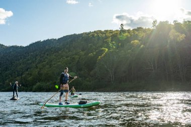 Khabarovsk, Rusya - 20 Eylül 2019: Su turistleri Sup kürek çekiyor Anyui dağ nehrinde güzel dağların ve vahşi yaşamın arka planına karşı kürek çekiyorlar