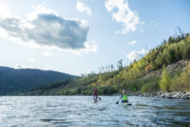 Khabarovsk, Rusya - 20 Eylül 2019: Su turistleri Sup kürek çekiyor Anyui dağ nehrinde güzel dağların ve vahşi yaşamın arka planına karşı kürek çekiyorlar