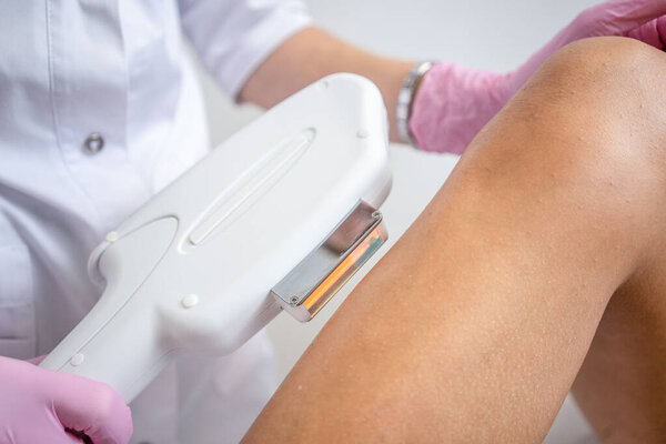 Laser hair removal on womens legs . white background close up