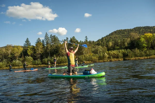 KHABAROVSK, RUSSIA - September 20, 2019 : Water tourists paddle SUP Stand up paddle board on the mountain river Anyui against the backdrop of beautiful mountains and wildlife — Stock Photo, Image